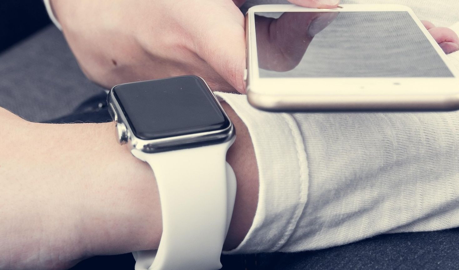 Persona che indossa smartwatch e controlla smartphone